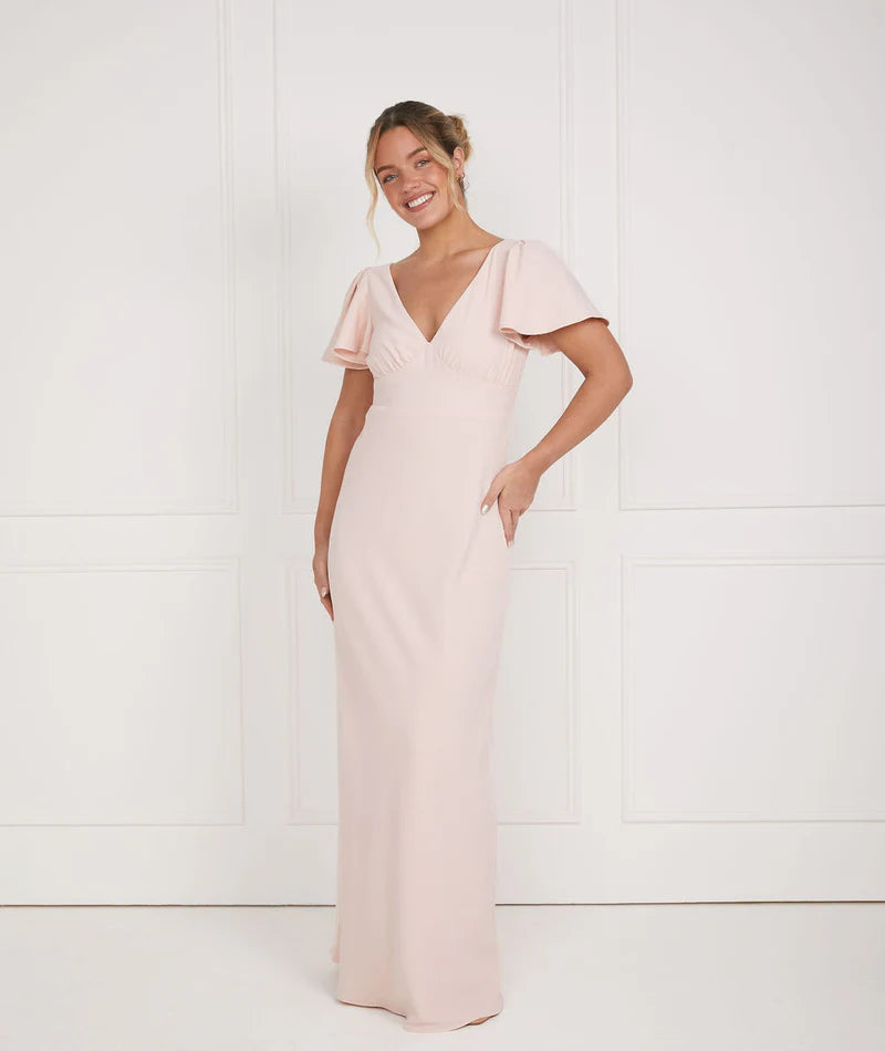 Woman wearing a pink dress against a white background