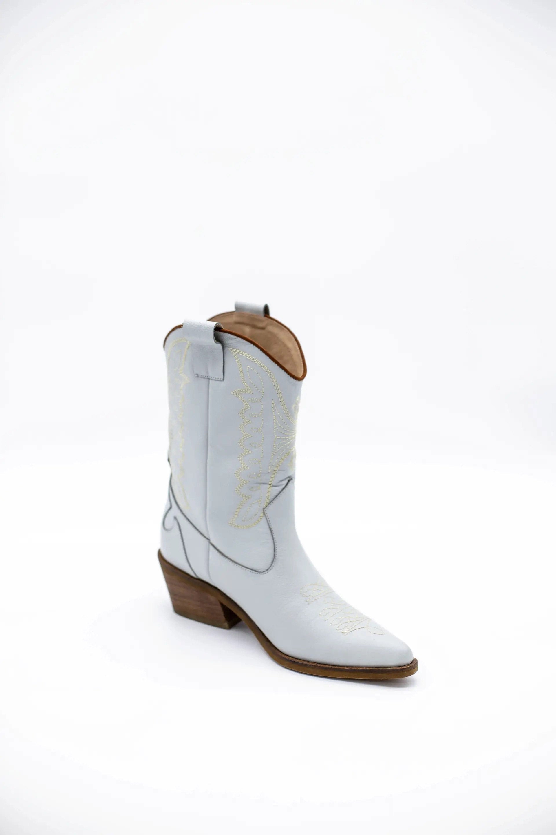 Introducing the Luna Cowboy Boot — a handcrafted statement piece designed for unstoppable style, comfort, and individuality. The Luna boot is where rustic tradition meets modern elegance, offering a fresh twist on the timeless cowboy boot silhouette. Whether you're walking down the aisle or dancing under the stars, Luna brings a unique edge to your look with artisanal detailing and heritage craftsmanship while offering that unique 'Something Blue' element.