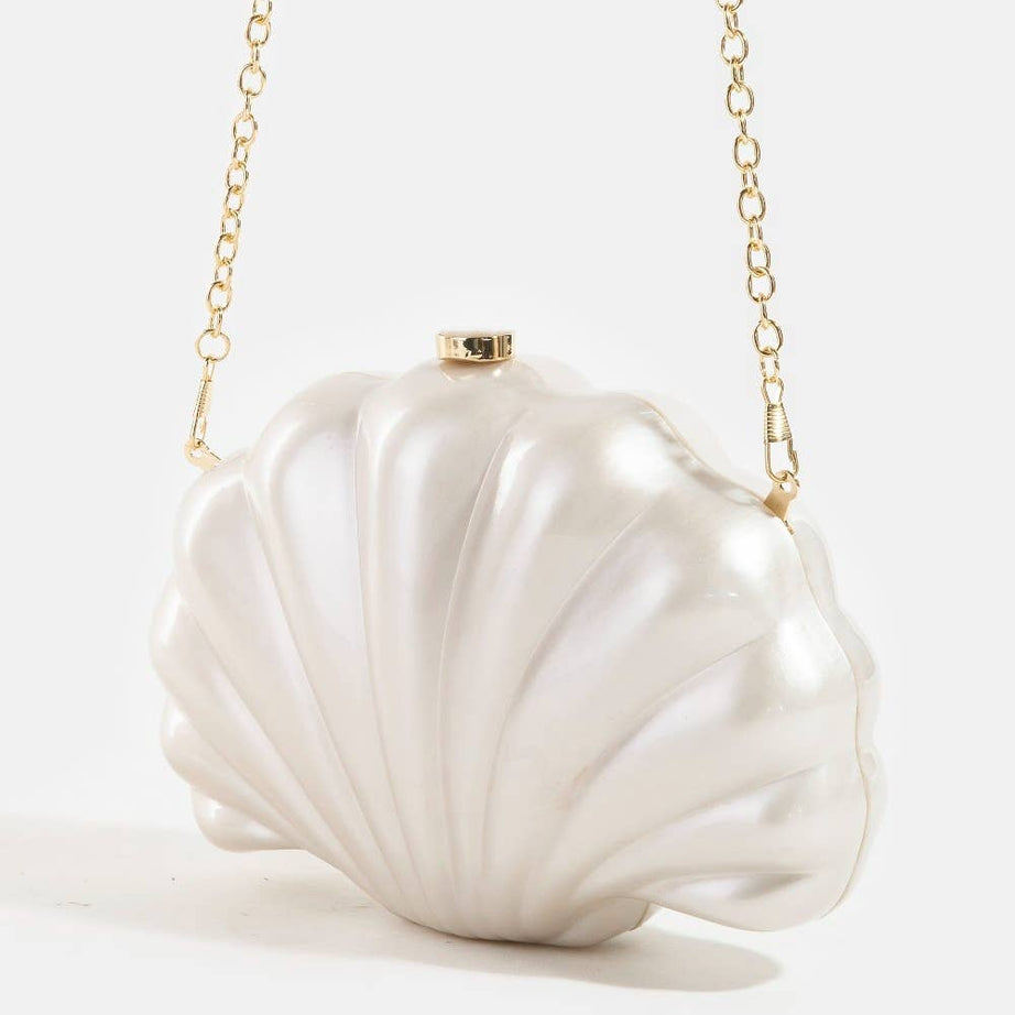 Shell-shaped white pearlescent bridal clutch bag on a light grey background