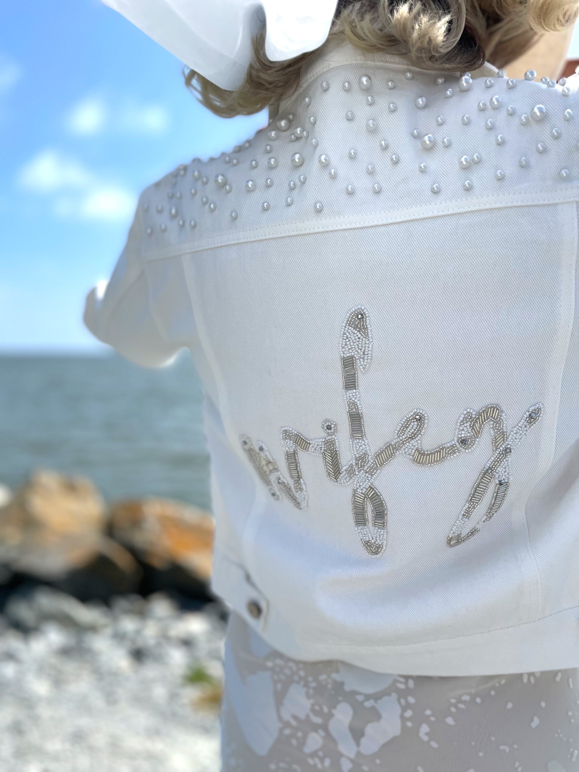 Lady wearing white wifey bridal jacket with pearl embellishments