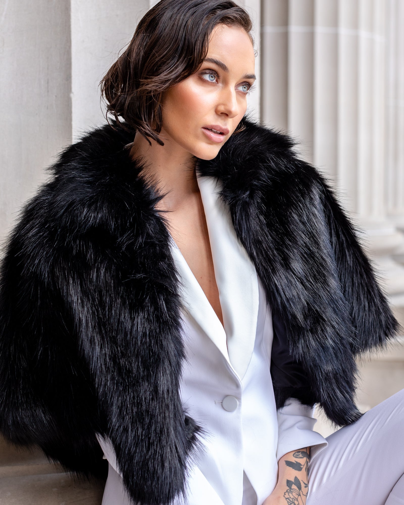 Woman wearing black faux fur cape

