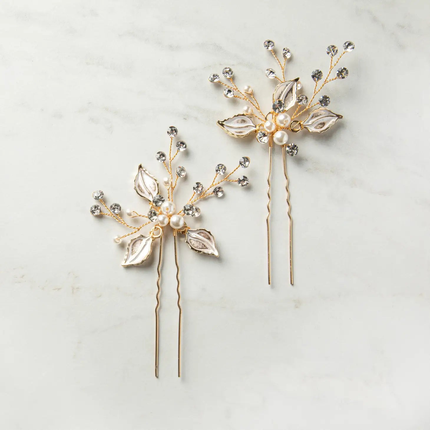 Graceful, ethereal, and delicately luminous — the&nbsp;Nina Hairpin Set is designed to capture the magic of your most cherished moments. This elegant set includes two handcrafted pins, each adorned with iridescent floral accents, soft ivory pearls, and sparkling crystal embellishments. Romantic and refined, the Nina pins are the perfect hair accessory for weddings, bridal parties, and formal celebrations where beauty is found in the finest of details.