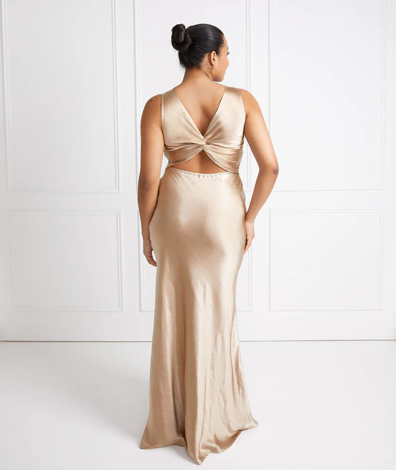 Woman wearing a gold bridesmaid evening gown with a white background