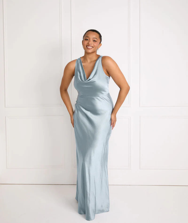 Woman wearing a light blue satin bridesmaid dress against a white background