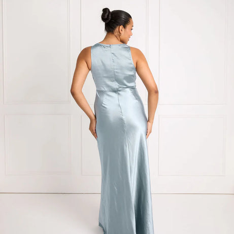 Woman wearing a light blue satin bridesmaid dress against a white background