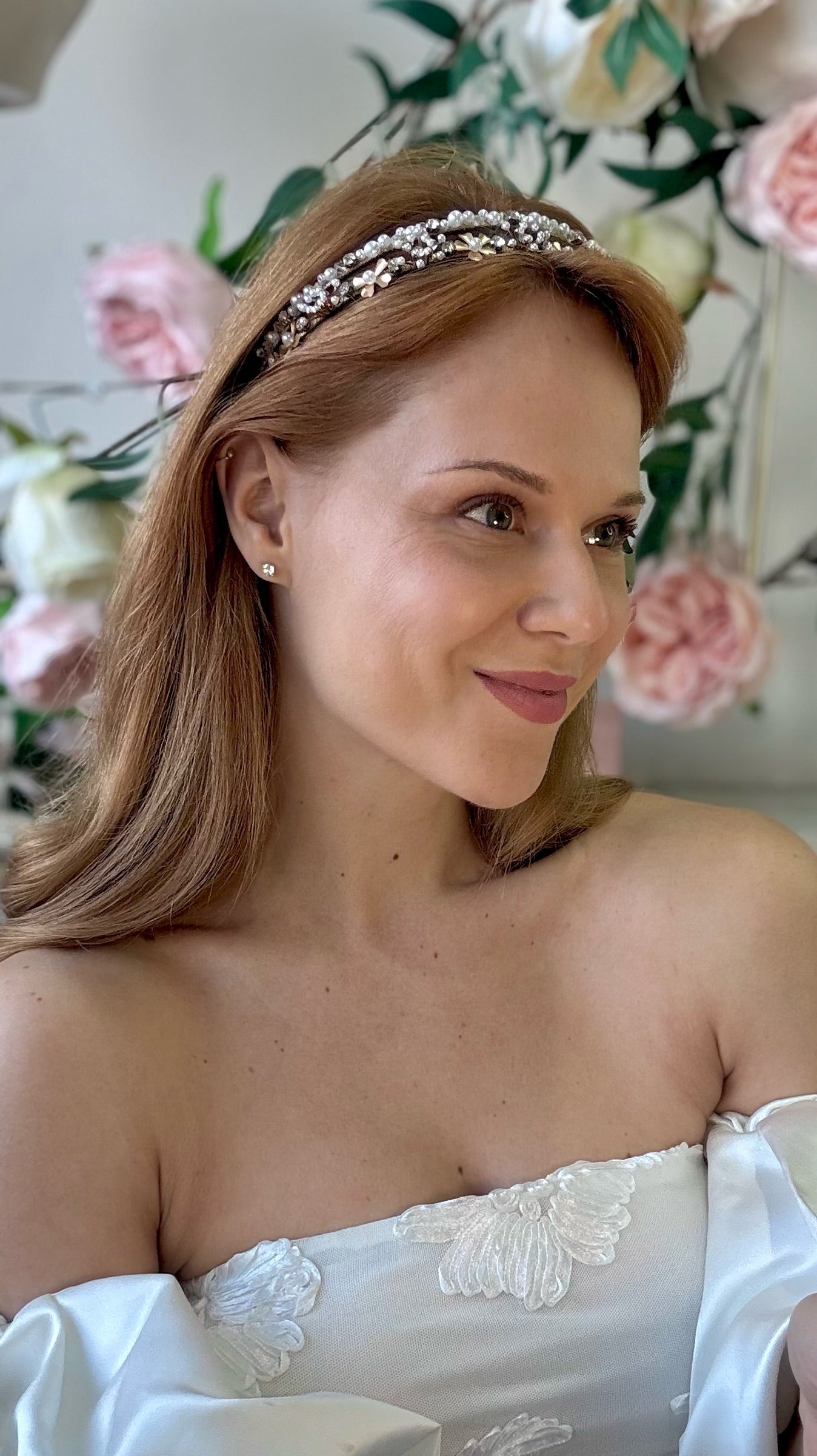 Woman wearing bridal tiara with floral decorations in the background