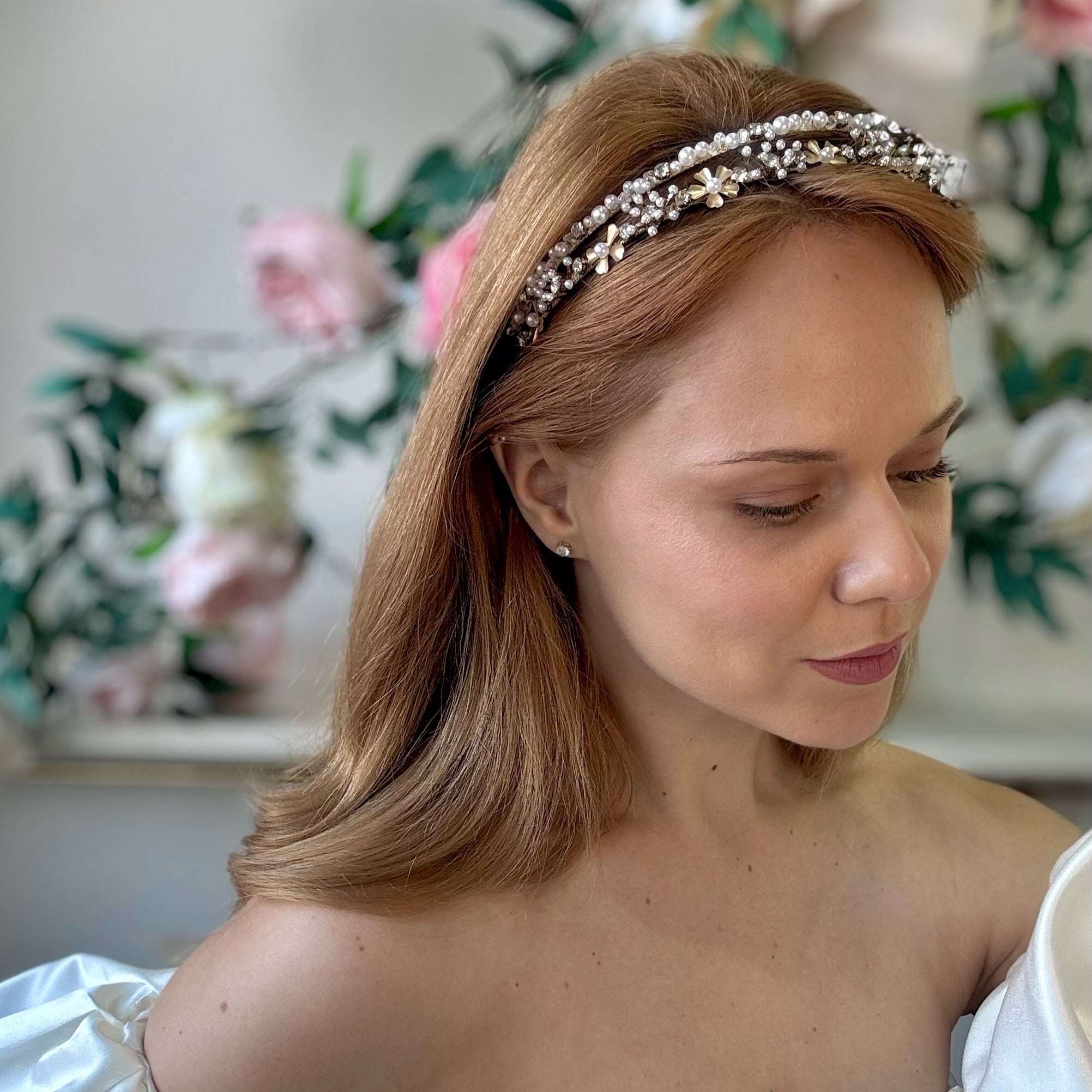 Woman wearing a decorative bridal headband with flowers in the background
