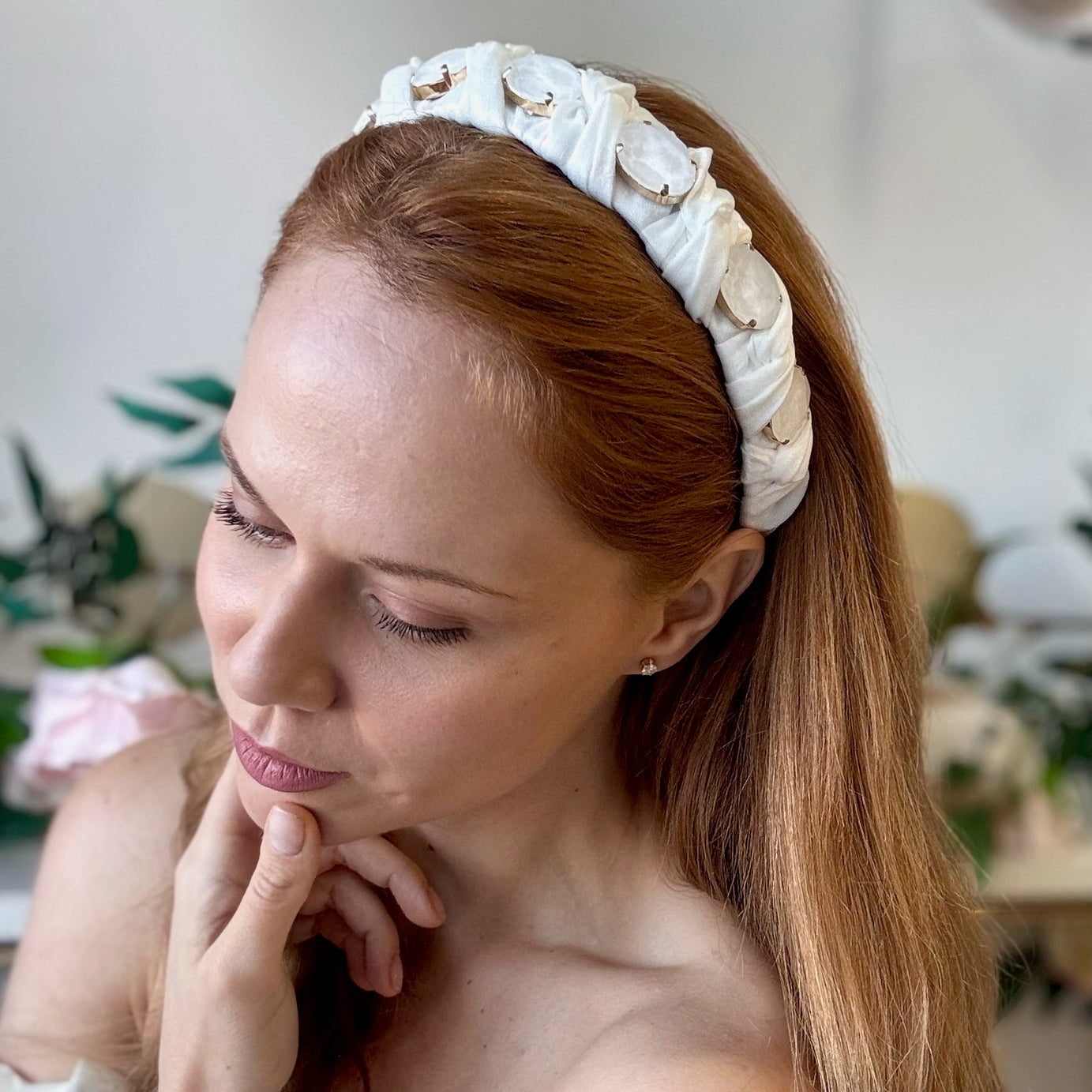 Lady wearing white bridal headband with crystals