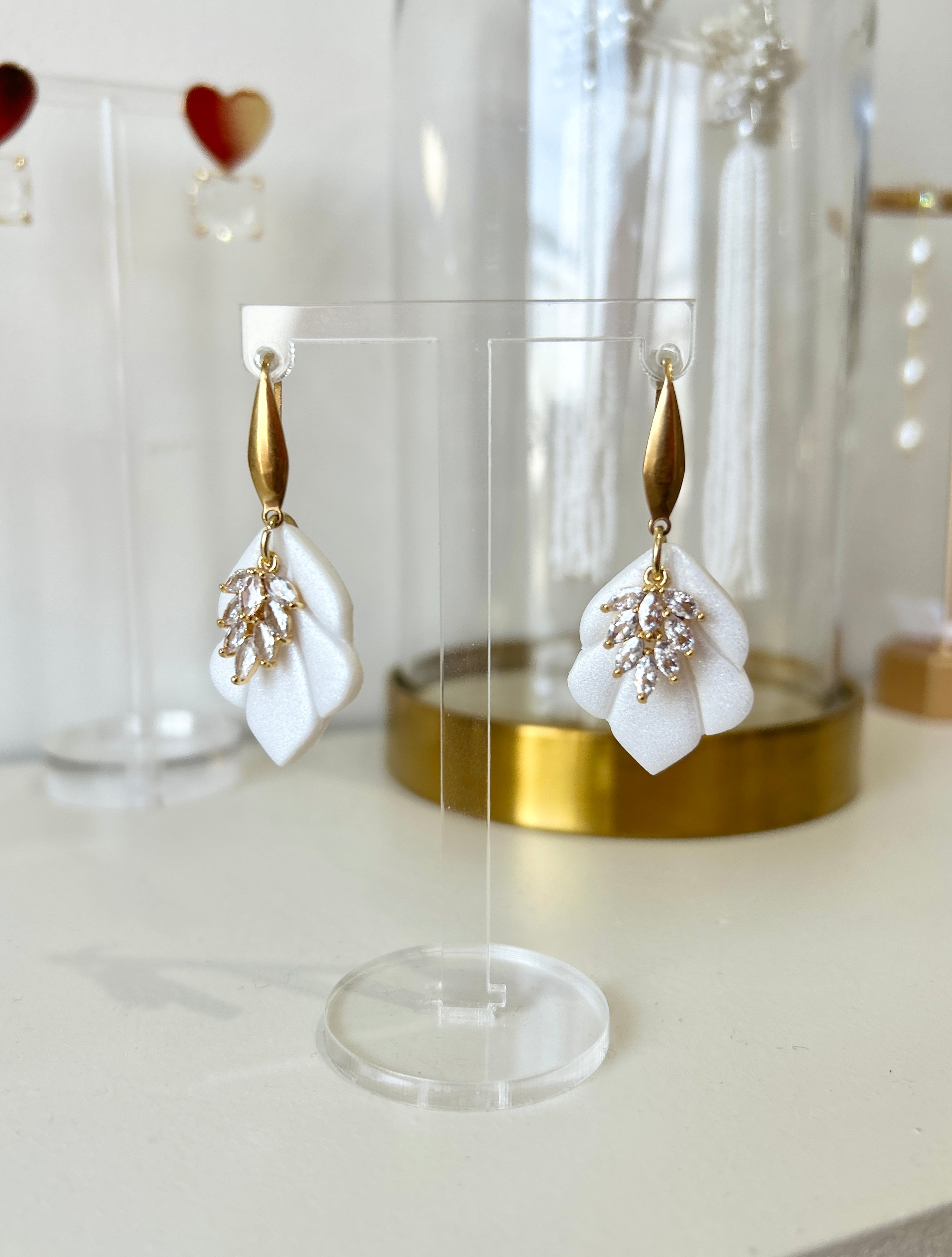 Bring a modern yet timeless touch to your bridal ensemble with the Sophie Ivory and Gold Bridal Earrings. Delicately crafted for the bride who loves effortless elegance, these earrings combine sleek design with soft, romantic details, offering a unique accessory that feels both elevated and easy to wear. Whether you're walking down the aisle, attending a rehearsal dinner, or dressing for a special occasion, the Sophie earrings are the perfect finishing touch