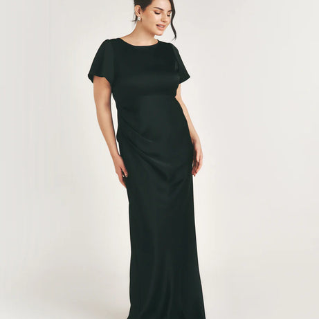 Woman wearing a black bridesmaid dress against a white background
