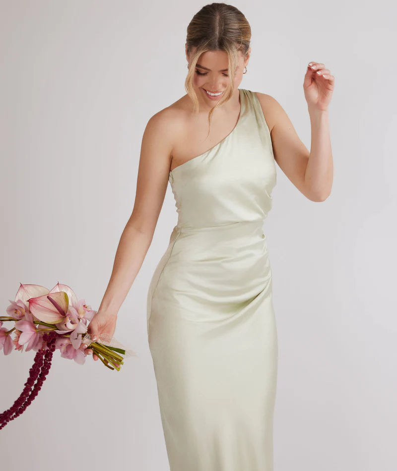 woman wearing pastel light green one shoulder bridesmaid dress