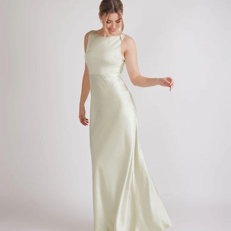 Woman wearing a long, pastel green satin dress on a white background