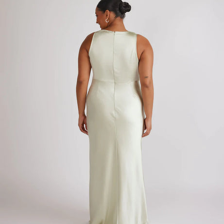 Woman wearing pastel green satin bridesmaid dress with cowl neck