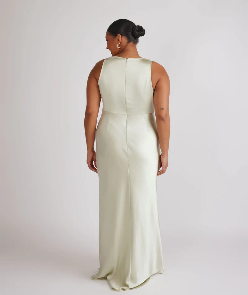 Woman wearing pastel green satin bridesmaid dress with cowl neck