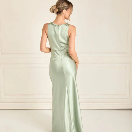 woman wearing satin bridesmaid dress in sage green with cowl neck