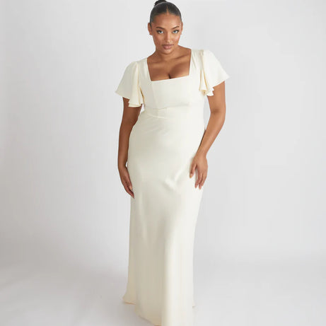 Woman wearing the Cressida, square neck flutter sleeve bridesmaid dress by Six Stories in colour almond