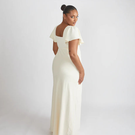 Woman wearing the Cressida, square neck flutter sleeve bridesmaid dress by Six Stories in colour almond