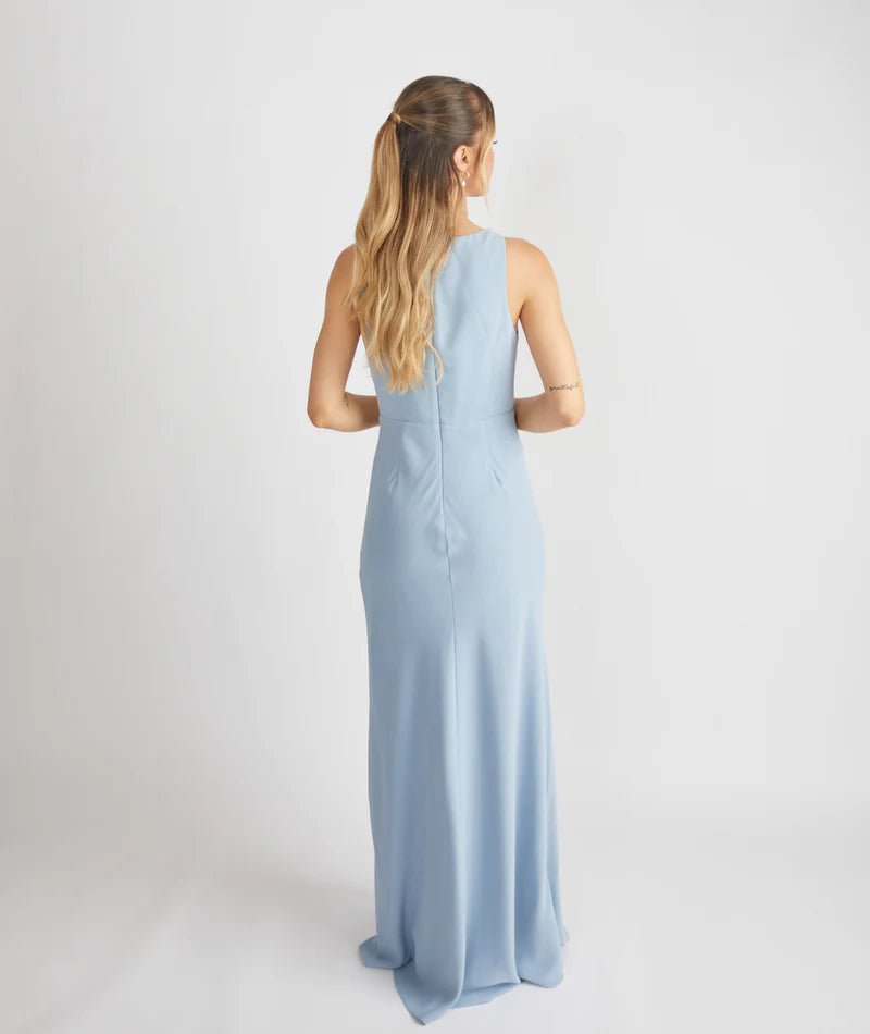 woman wearing dusty blue bridesmaid dress against a white background