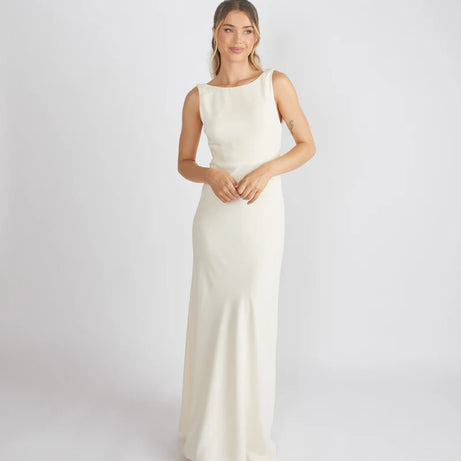 Woman wearing Six Stories crepe cowl back bridesmaid dress in colour Almond