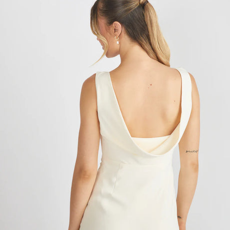 Woman wearing Six Stories crepe cowl back bridesmaid dress in colour Almond