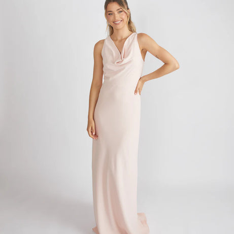 Woman wearing a long, light pink dress against a white background