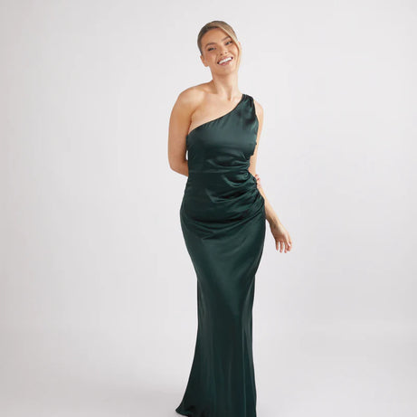 woman wearing Six Stories one shoulder satin bridesmaid dress in emerald green