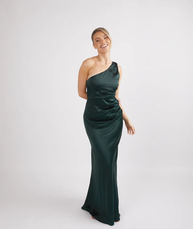 woman wearing Six Stories one shoulder satin bridesmaid dress in emerald green