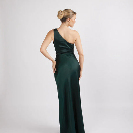 woman wearing Six Stories one shoulder satin bridesmaid dress in emerald green