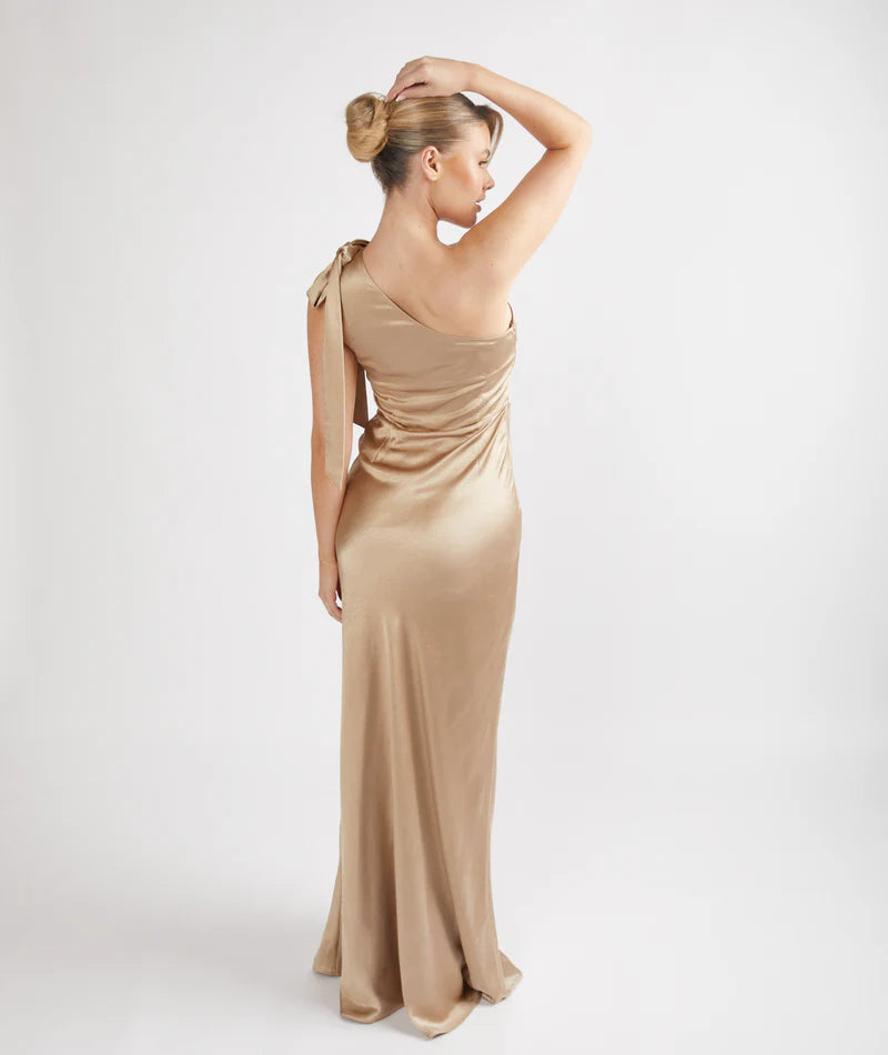 Woman wearing a champagne satin one-shoulder bridesmaid dress on a white background