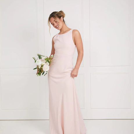 girl wearing soft pink bridesmaid dresses with cowl back by six stories
