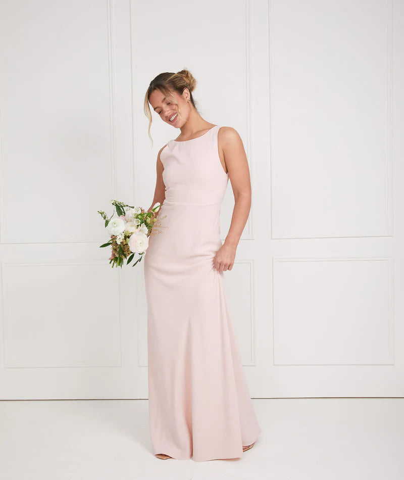 girl wearing soft pink bridesmaid dresses with cowl back by six stories