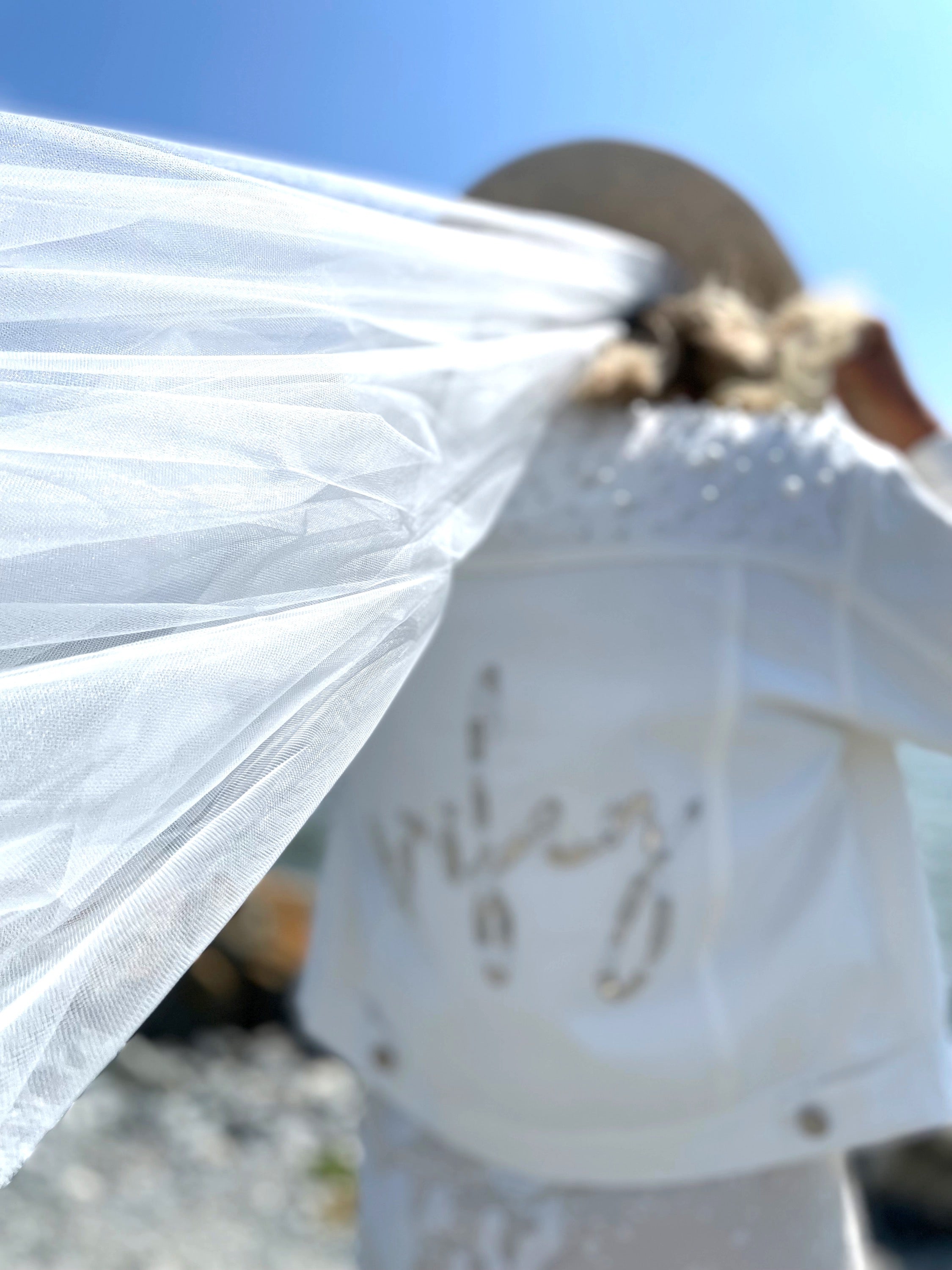 Lady wearing white wifey bridal jacket with pearl embellishments