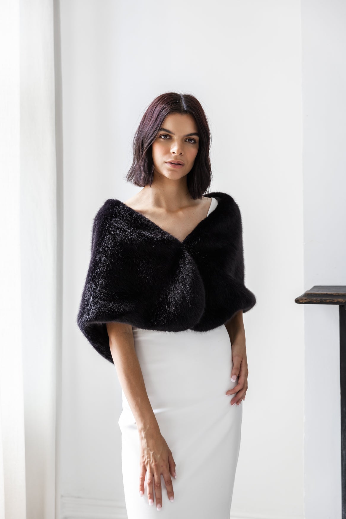 Woman wearing black off the shoulder black faux fur wrap
