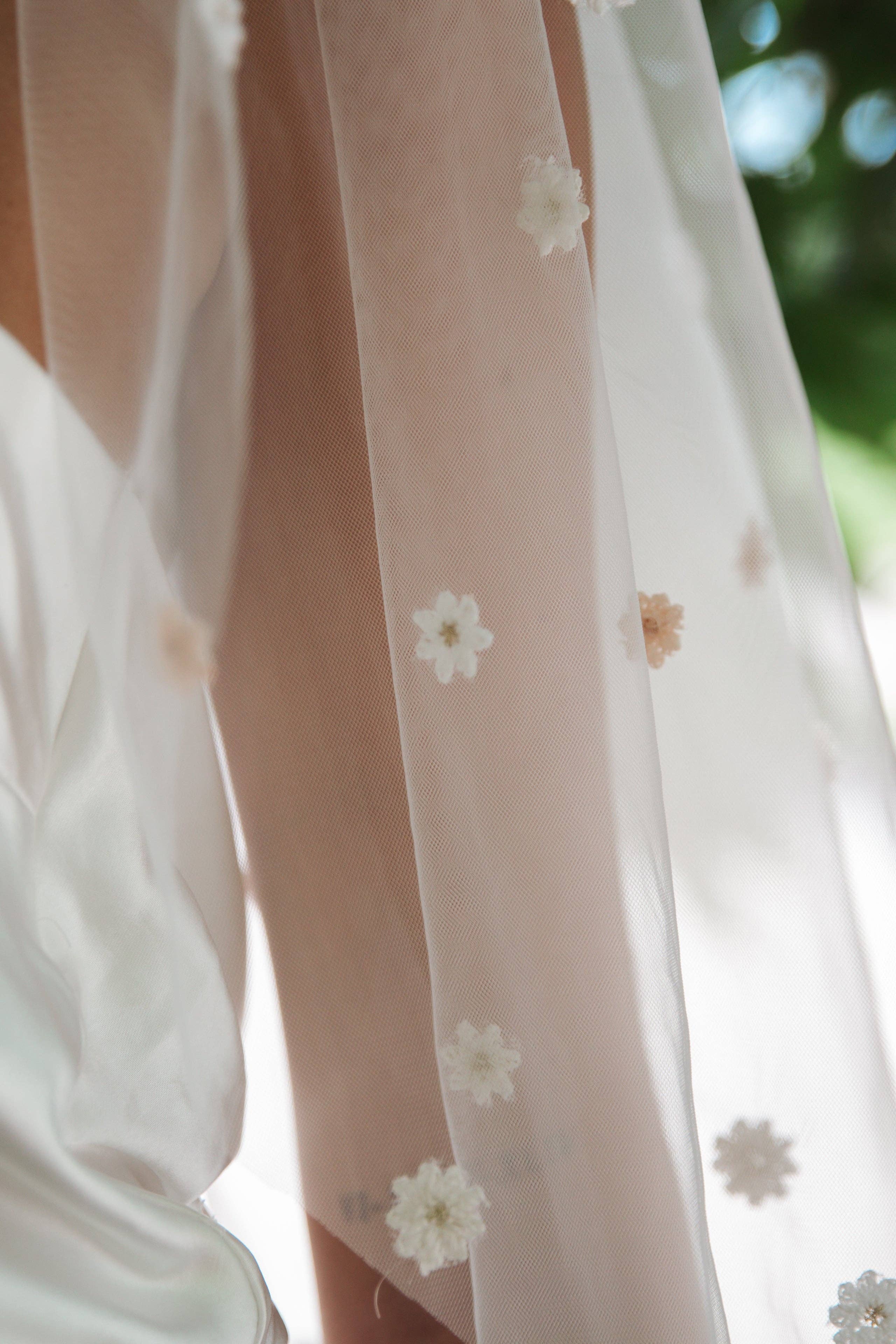 Fun and whimsical wedding veil with flowers in soft pastel shades