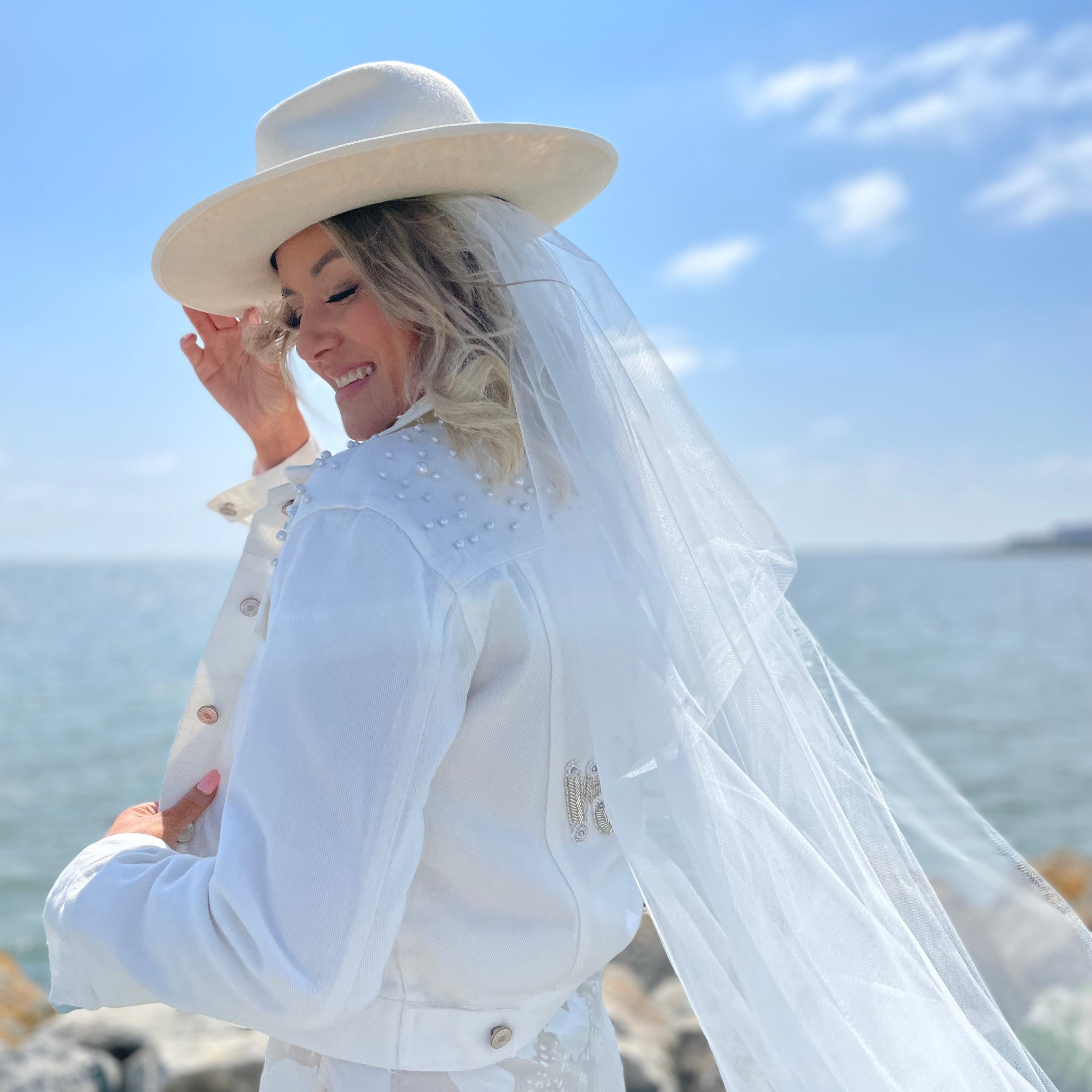Lady wearing white wifey bridal jacket with pearl embellishments