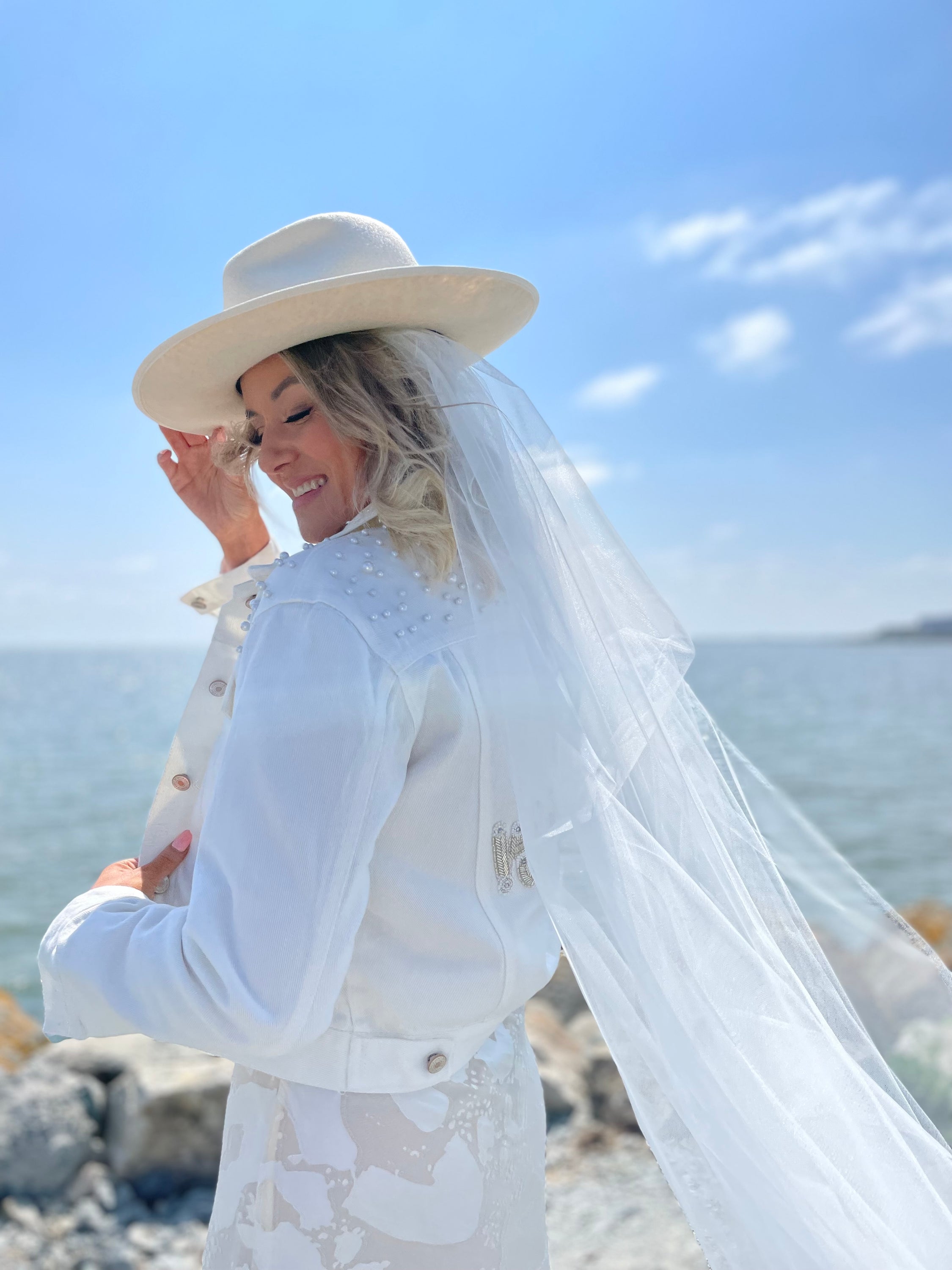 Lady wearing white wifey bridal jacket with pearl embellishments