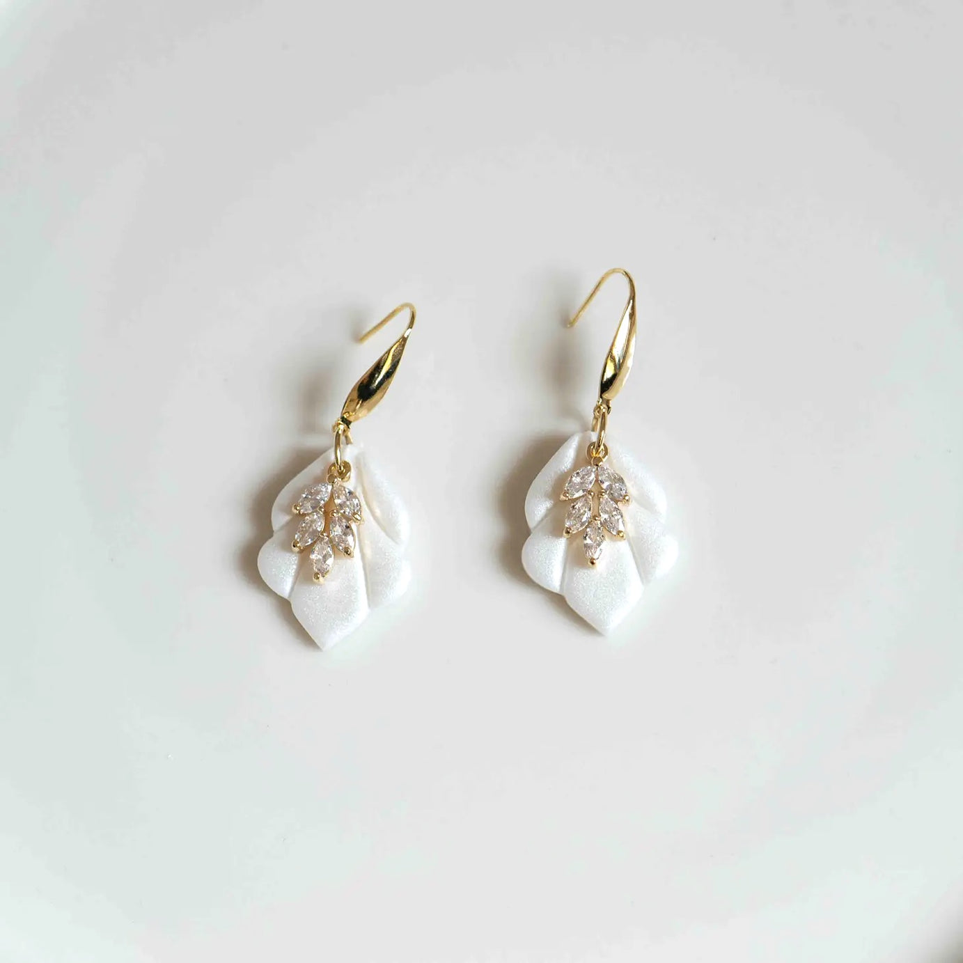 Bring a modern yet timeless touch to your bridal ensemble with the Sophie Ivory and Gold Bridal Earrings. Delicately crafted for the bride who loves effortless elegance, these earrings combine sleek design with soft, romantic details, offering a unique accessory that feels both elevated and easy to wear. Whether you're walking down the aisle, attending a rehearsal dinner, or dressing for a special occasion, the Sophie earrings are the perfect finishing touch
