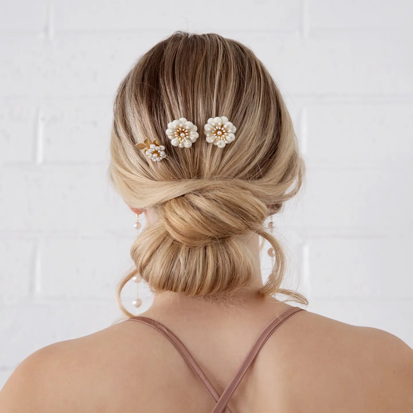 Add a touch of floral elegance to your look with the Daisy trio Hairpin Set — the perfect finishing touch for brides, bridesmaids, or anyone attending a special occasion. Handcrafted with delicate gold-toned wiring and shimmering crystal accents, these pins bring effortless elegance and luminous detail to any hairstyle.