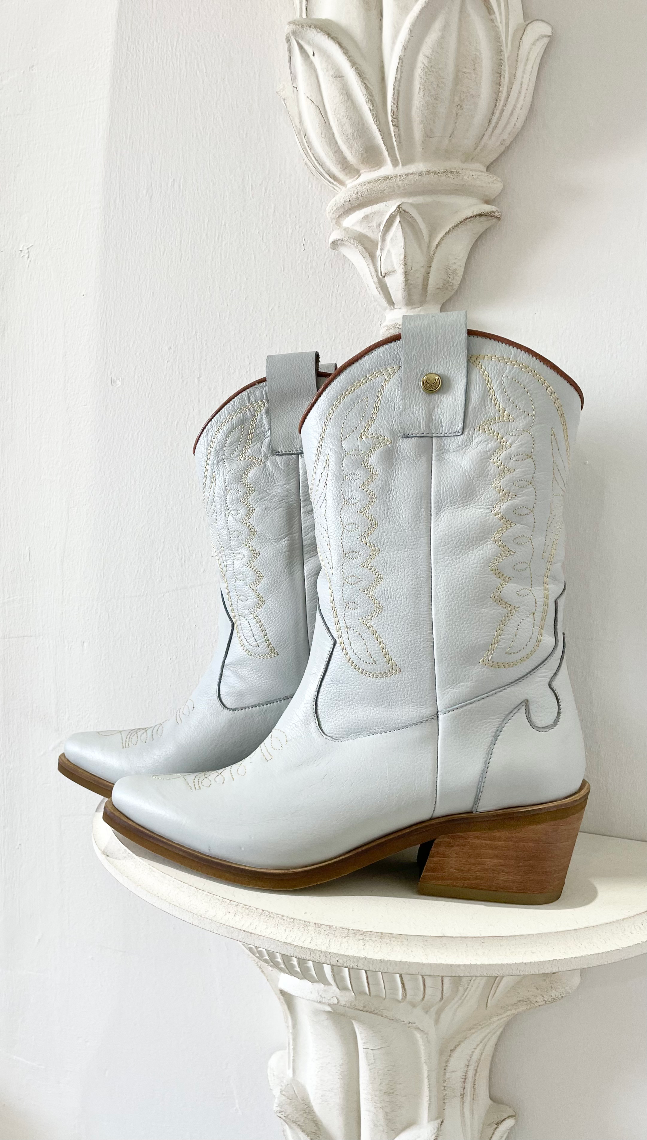 Introducing the Luna Cowboy Boot — a handcrafted statement piece designed for unstoppable style, comfort, and individuality. The Luna boot is where rustic tradition meets modern elegance, offering a fresh twist on the timeless cowboy boot silhouette. Whether you're walking down the aisle or dancing under the stars, Luna brings a unique edge to your look with artisanal detailing and heritage craftsmanship while offering that unique 'Something Blue' element.